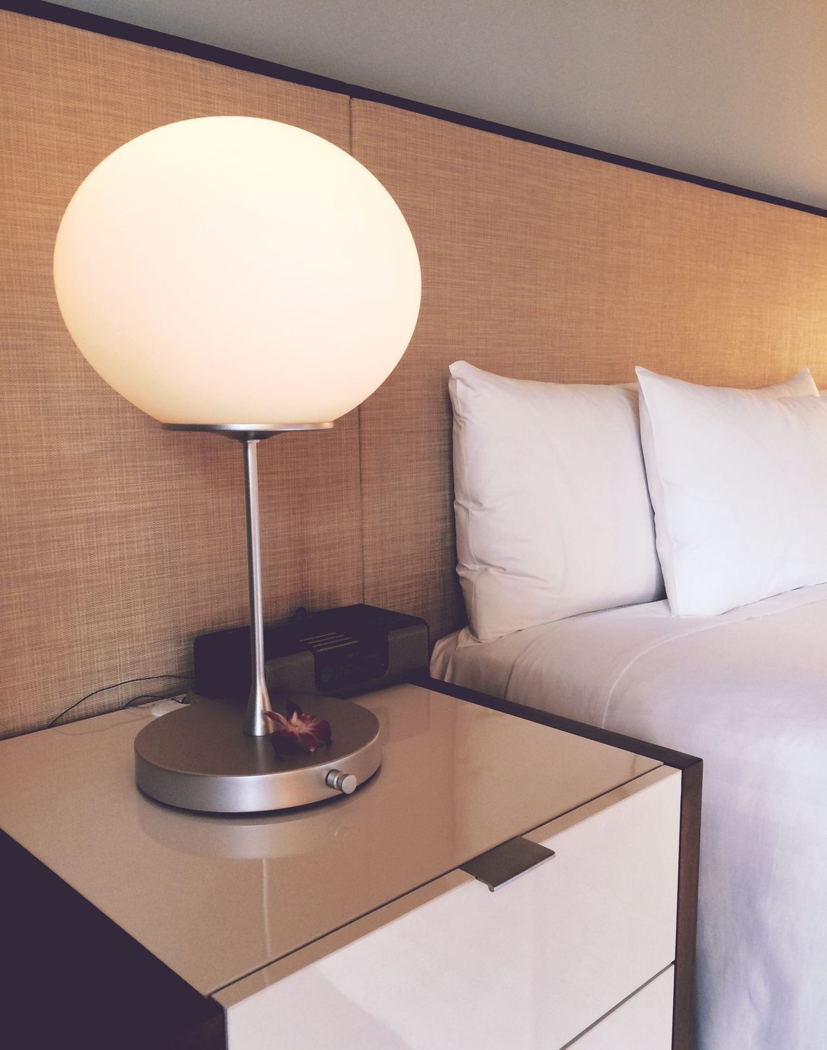 Helles, frisch gemachtes Hotelzimmer mit sauberem Bett und aufger&auml;umtem Nachttisch