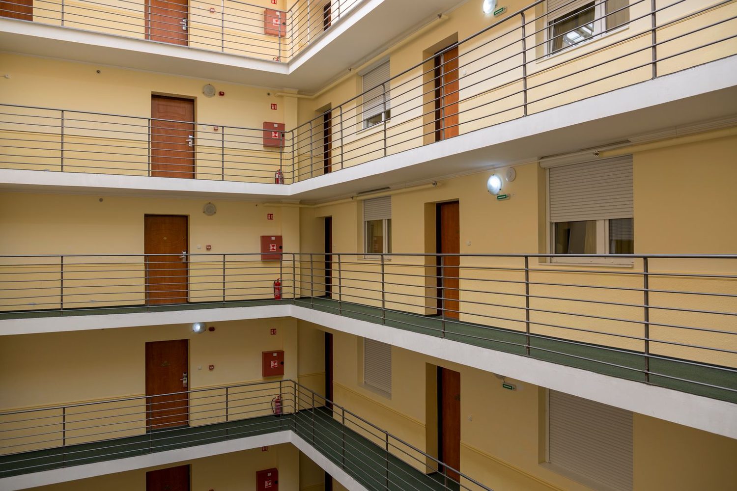 Heller, gepflegter Laubengang in einem Mehrfamilienhaus, sauberes Treppenhaus