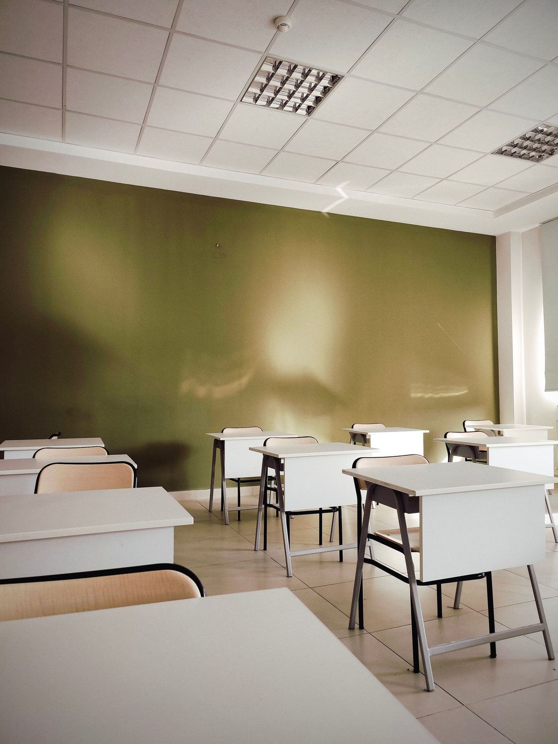 Helles, aufger&auml;umtes Klassenzimmer mit leeren Tischen, frisch gereinigt