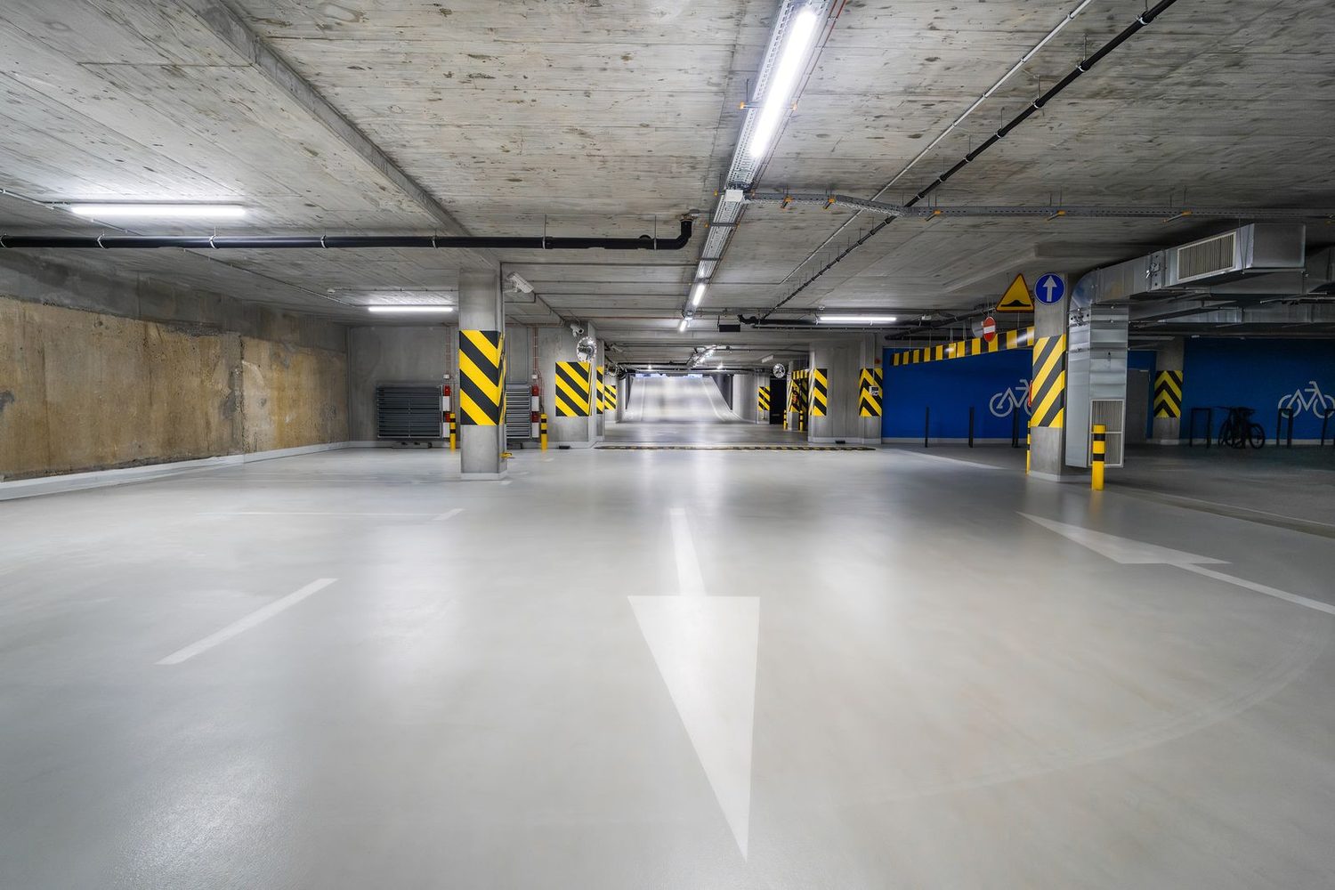 Helle, saubere Tiefgarage mit frisch gereinigter Fahrbahn und klaren Bodenmarkierungen